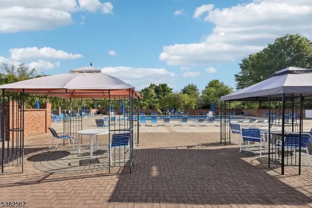 a view of a patio with table and chairs a fire pit and large trees