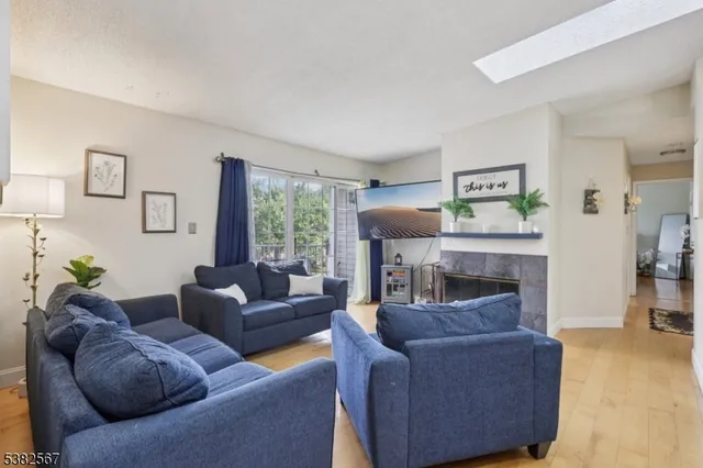 a living room with furniture kitchen and a wooden floor