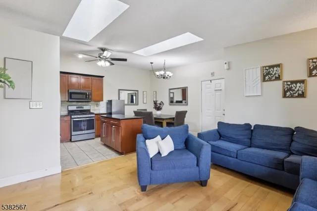 a dining room with furniture a chandelier and kitchen view