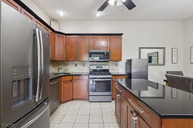 a kitchen with stainless steel appliances granite countertop a sink a stove and a microwave