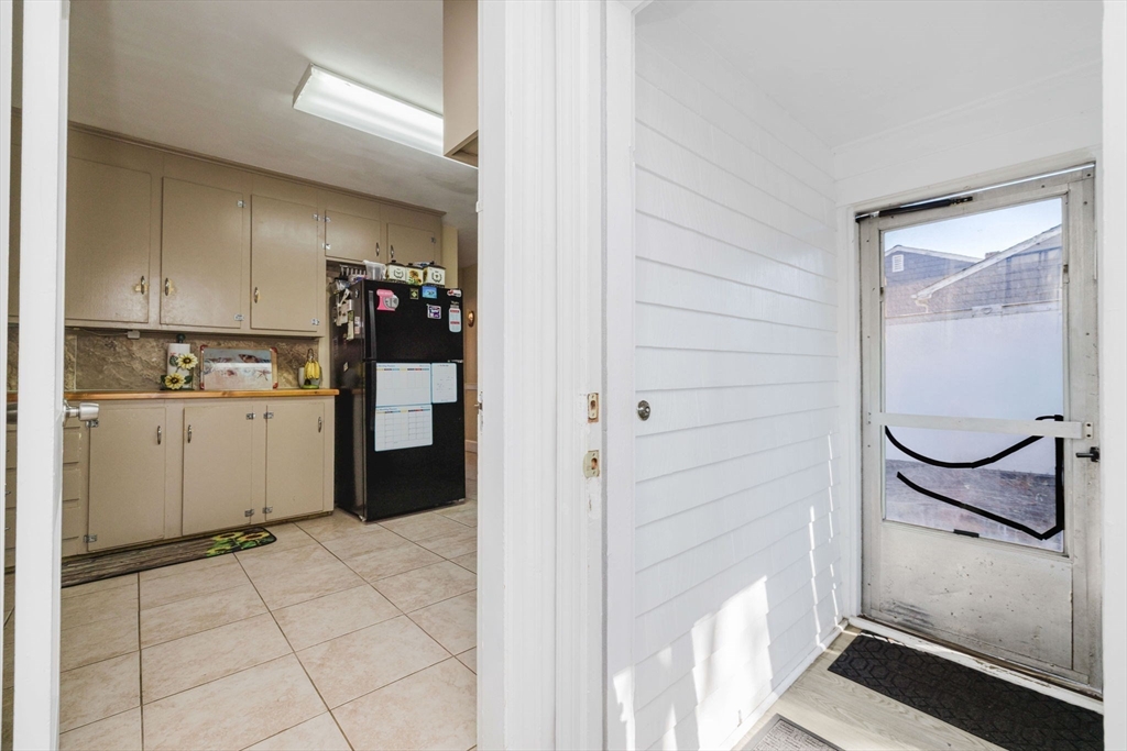 75 Randolph Avenue Tiverton, RI 02878 - Photo 7 of 22 a kitchen with a refrigerator and cabinets