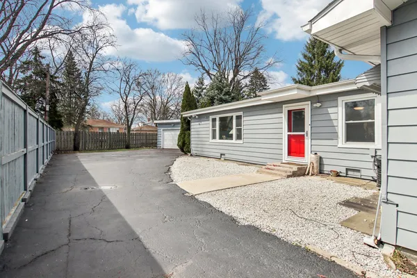 a backyard of a house with wooden fence and large trees