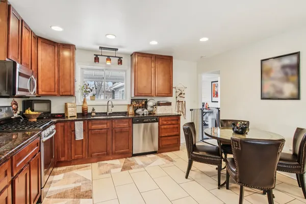 a kitchen with stainless steel appliances granite countertop a stove top oven a sink dishwasher and a refrigerator