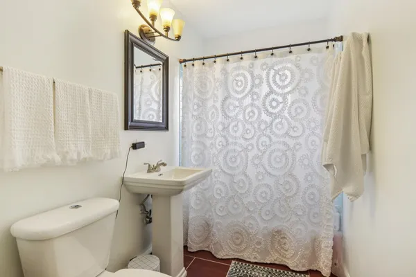 a bathroom with a sink a toilet and a mirror