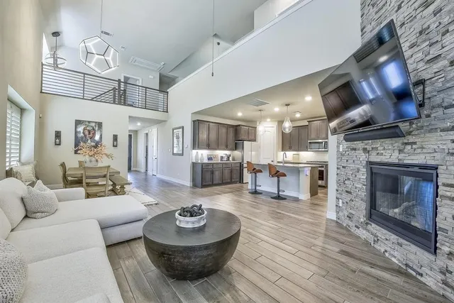 a living room with furniture a large window and a fireplace
