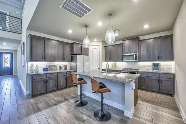 a kitchen with granite countertop kitchen island a stove a counter space and wooden floor