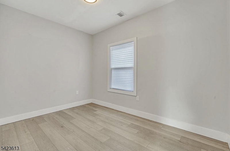 626 South 20th Street, Unit 3 Newark, NJ 07103 - Photo 7 of 13 an empty room with wooden floor and windows