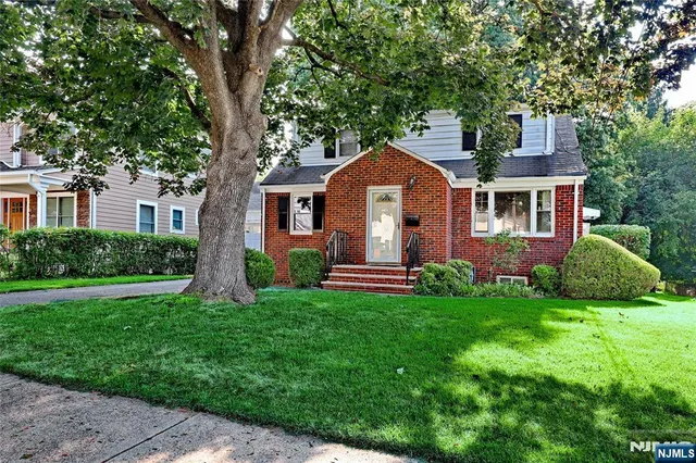 a front view of a house with a garden and yard