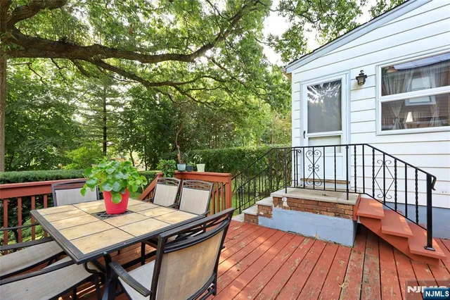 a view of a patio with table and chairs with wooden floor and fence