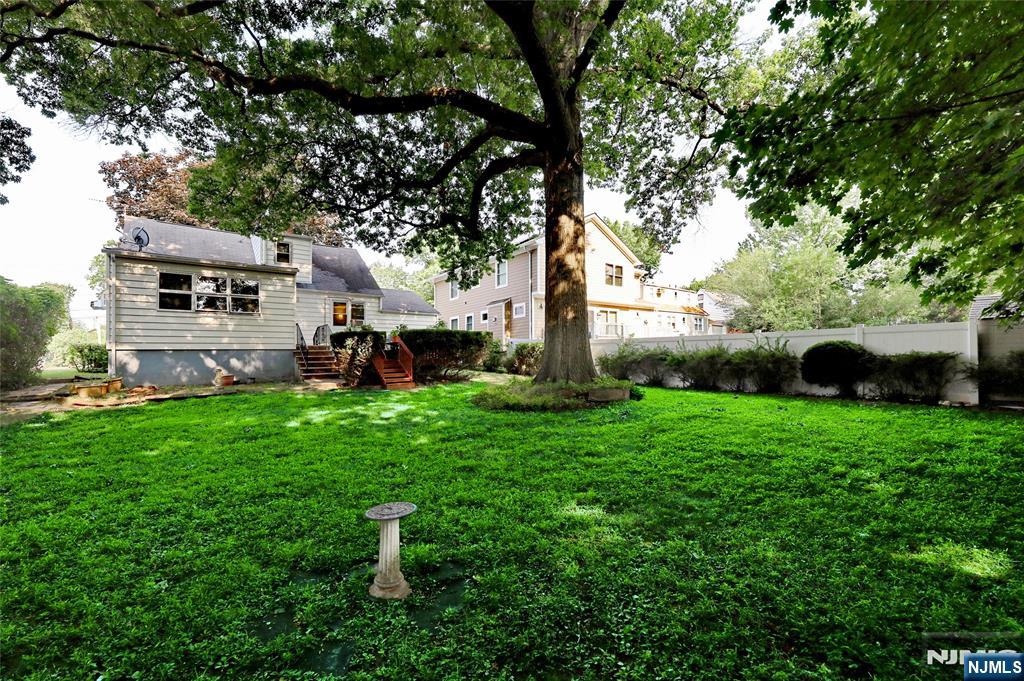136 Elm Street Cresskill, NJ 07626 - Photo 19 of 24 a view of a backyard with couches plants and large tree