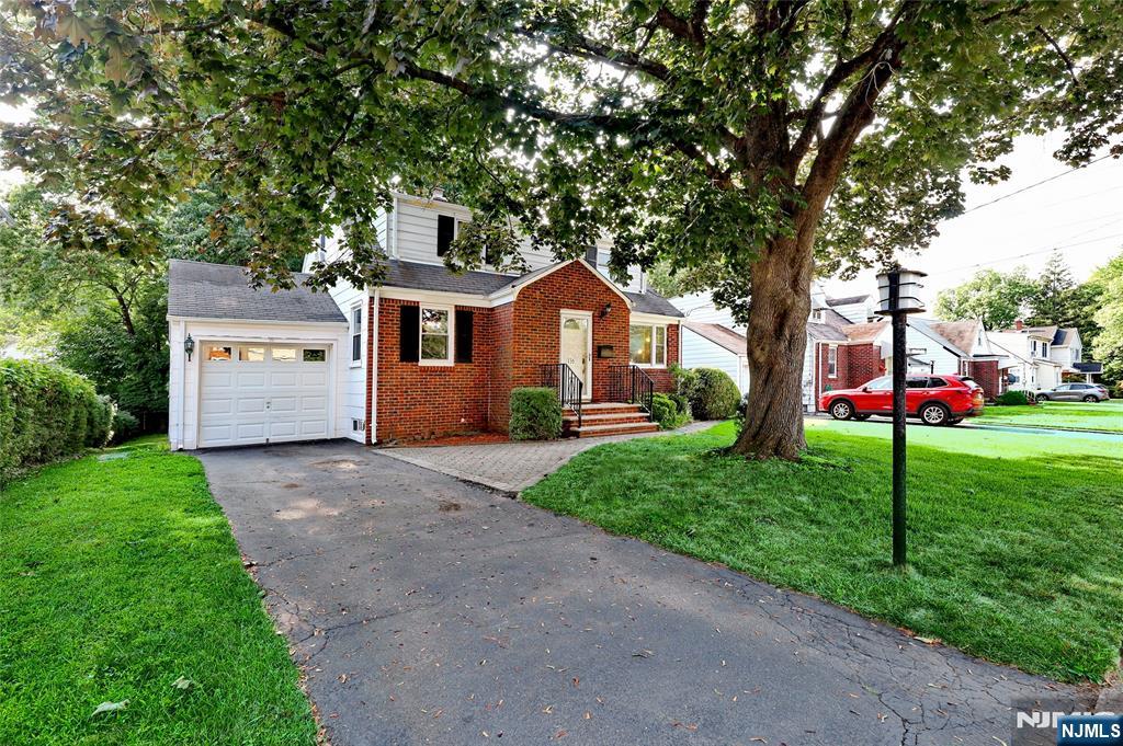 136 Elm Street Cresskill, NJ 07626 - Photo 2 of 24 a front view of a house with a yard and garage