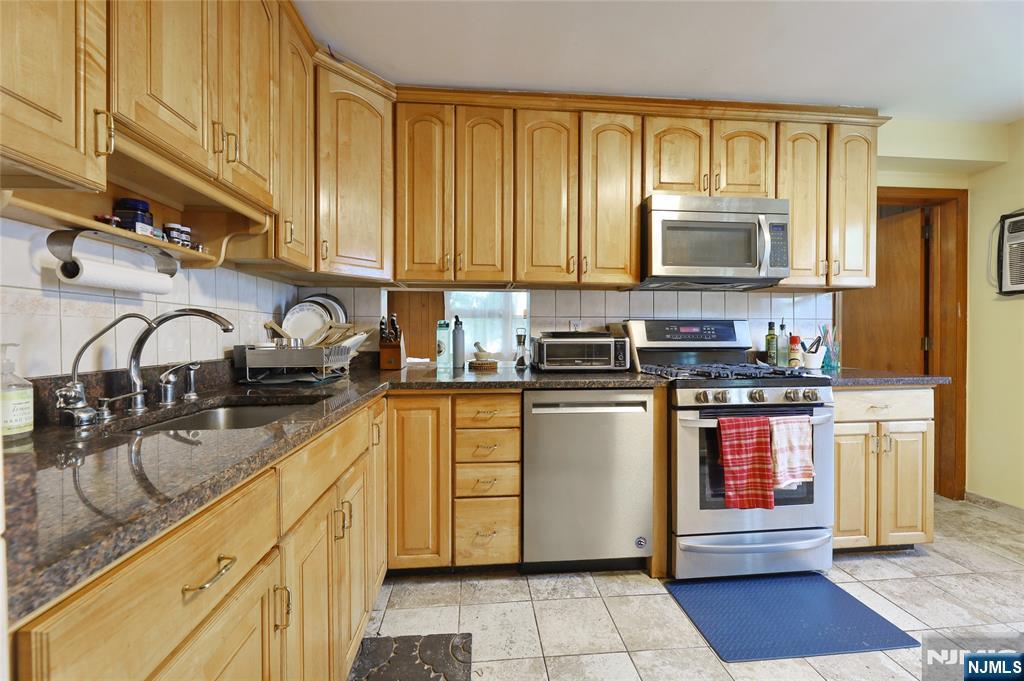 136 Elm Street Cresskill, NJ 07626 - Photo 5 of 24 a kitchen with stainless steel appliances granite countertop a stove a sink and a microwave