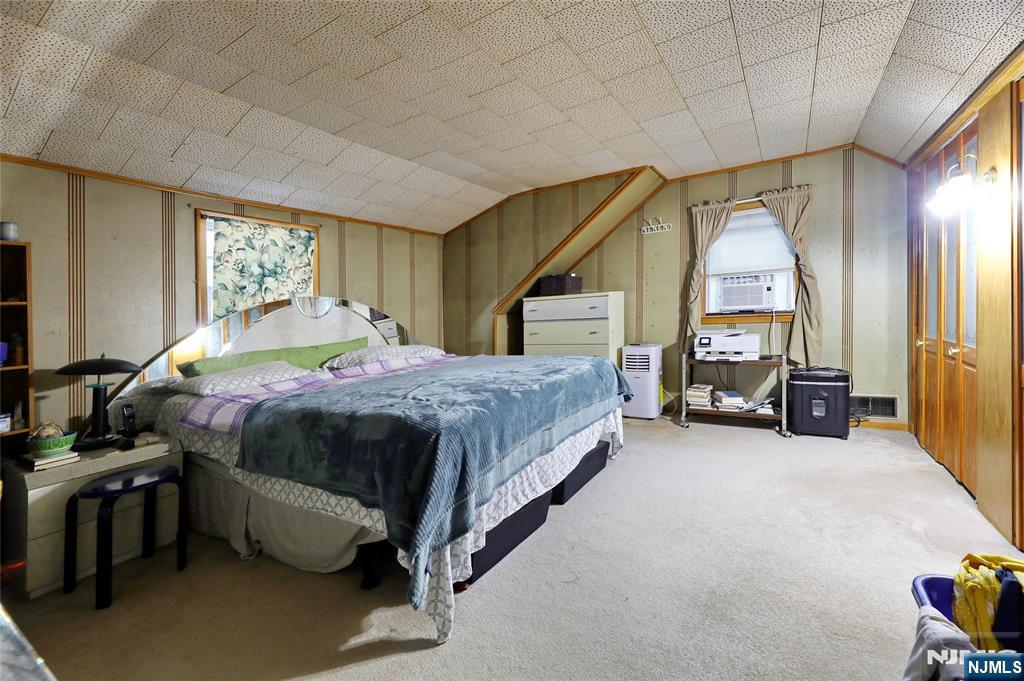 136 Elm Street Cresskill, NJ 07626 - Photo 9 of 24 a spacious bedroom with a bed and a chandelier