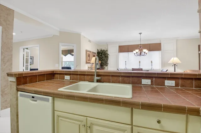 a view of a kitchen counter top a sink and dishwasher with wooden floor