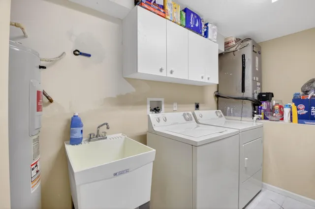 a utility room with sink dryer and washer