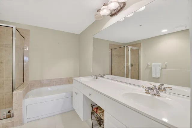 a bathroom with a bathtub double vanity sink and a mirror