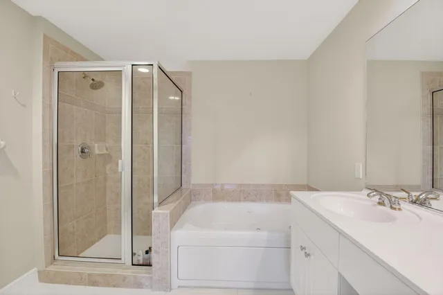 a bathroom with a sink and mirror with shower