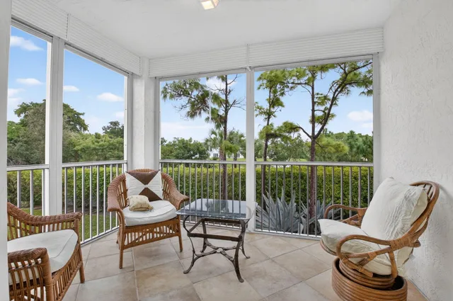 a living room with patio furniture and a floor to ceiling window