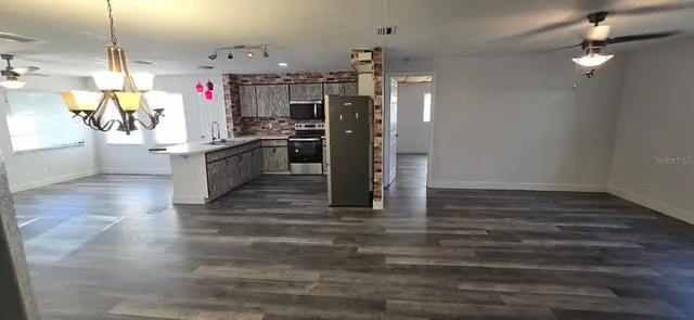 a kitchen with granite countertop a refrigerator and a stove top oven