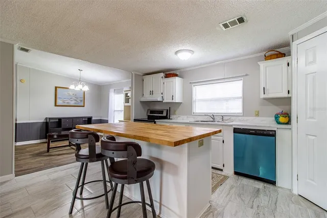 a kitchen with granite countertop a refrigerator sink and cabinets
