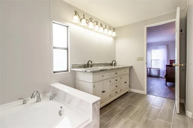 a bathroom with a tub sink and window