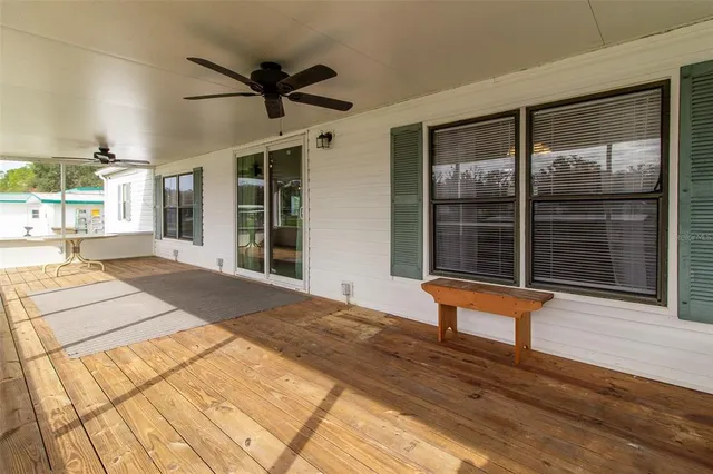 a view of a terrace with wooden floor and a floor to ceiling window