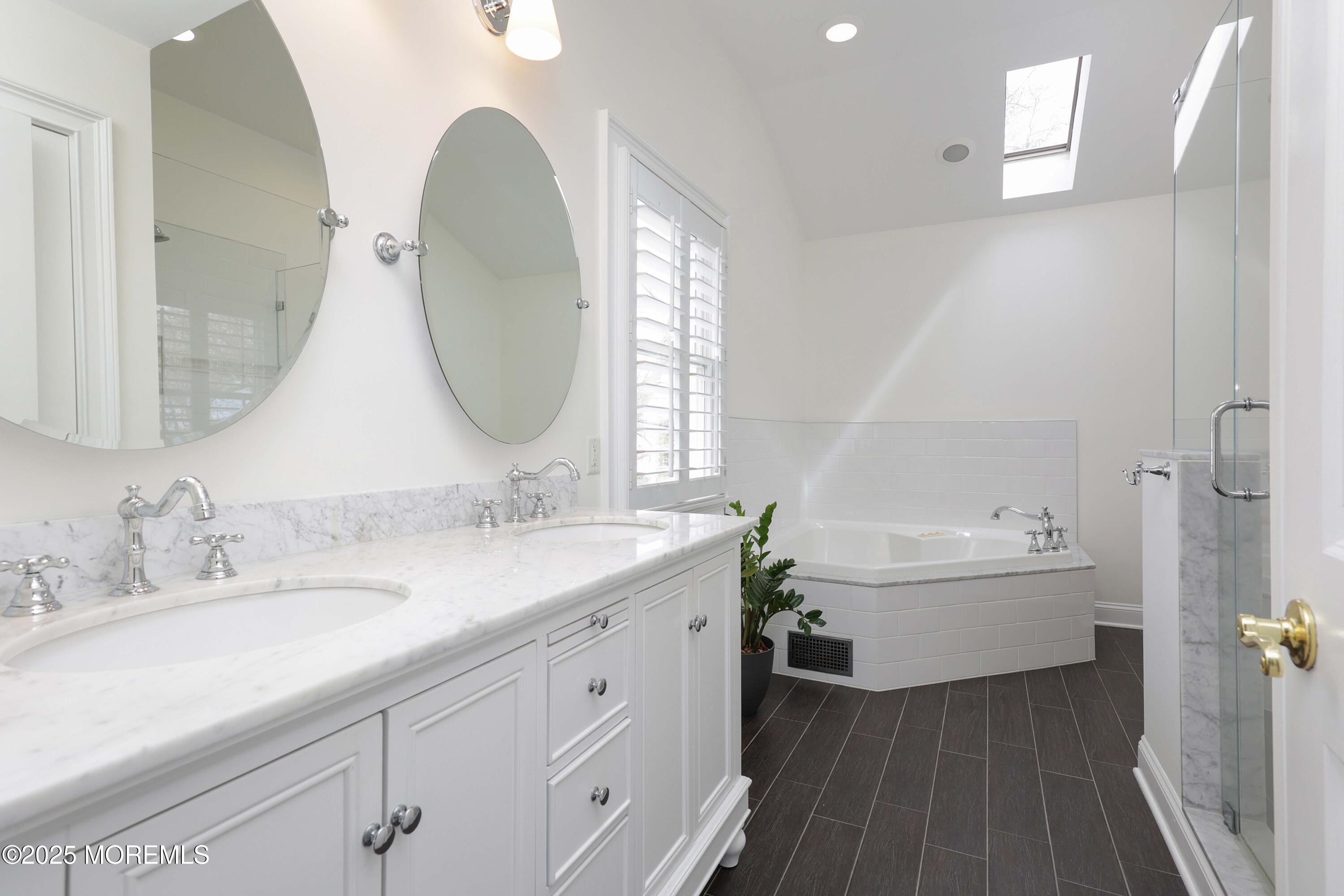 105 Black Point Road Rumson, NJ 07760 - Photo 16 of 27 a bathroom with a double vanity sink and a bathtub