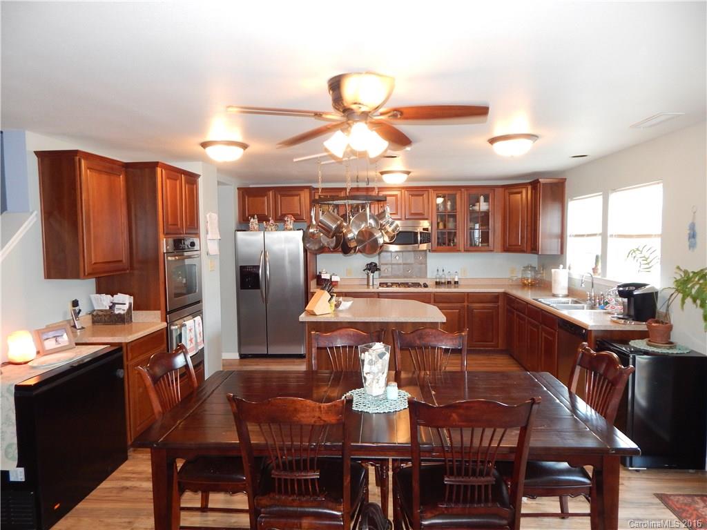 2166 Durand Road, Unit 39 Fort Mill, SC 29715 - Photo 9 of 23 a kitchen with stainless steel appliances granite countertop a sink a stove a dining table and chairs