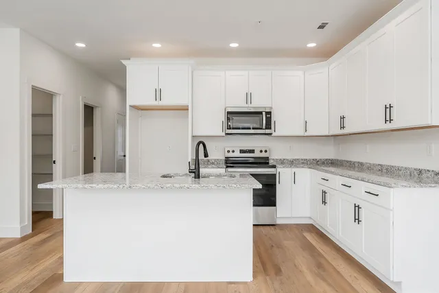 a kitchen with granite countertop a stove and a sink