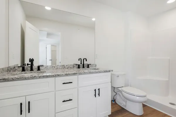 a bathroom with a granite countertop sink toilet and shower