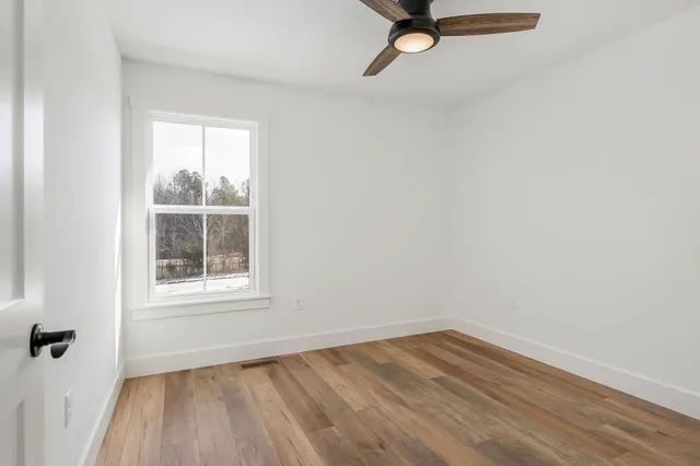 a view of a room with wooden floor and white walls