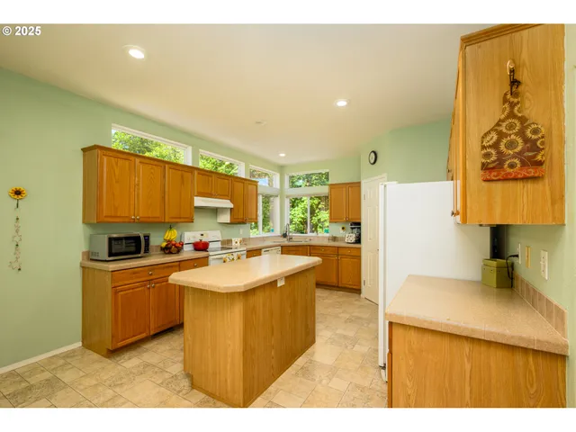 a kitchen with granite countertop a sink a counter top space and stainless steel appliances