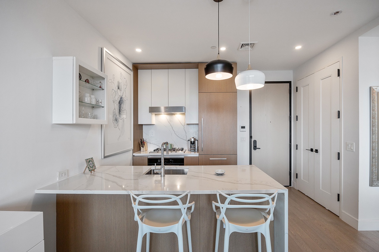 22-43 Jackson Avenue, Unit 8D Queens, NY 11101 - Photo 3 of 16 a kitchen with a dining table chairs and white cabinets