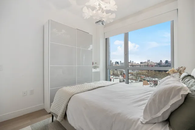 a bedroom with a bed and a large window