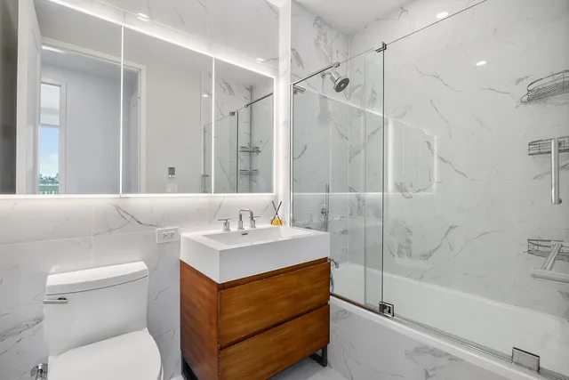 a bathroom with a sink toilet vanity and shower