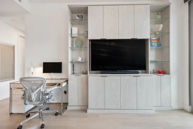 a view of a livingroom with a flat screen tv a fireplace and a window