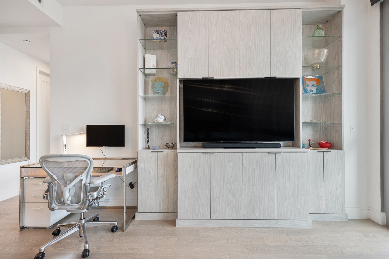 22-43 Jackson Avenue, Unit 8D Queens, NY 11101 - Photo 7 of 16 a view of a livingroom with a flat screen tv a fireplace and a window