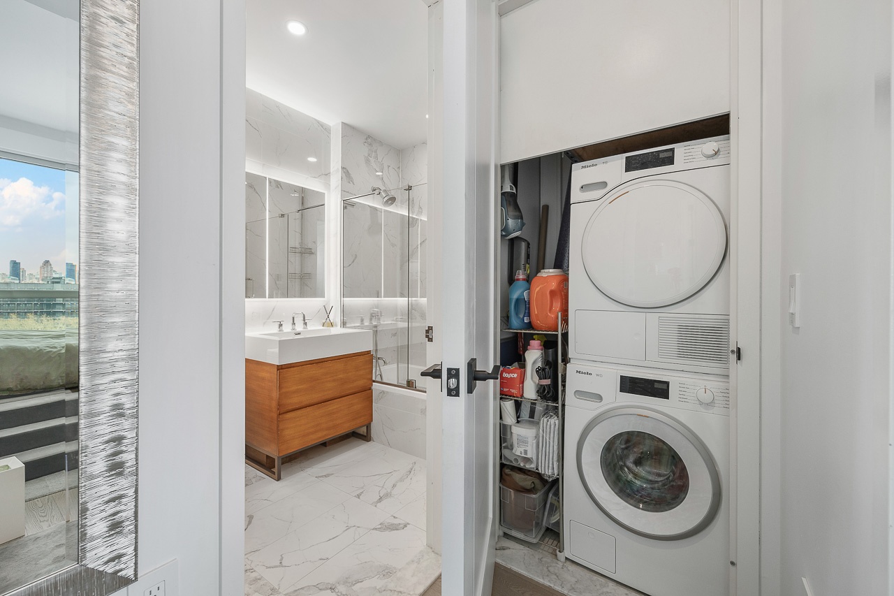 22-43 Jackson Avenue, Unit 8D Queens, NY 11101 - Photo 9 of 16 a utility room with dryer and washer