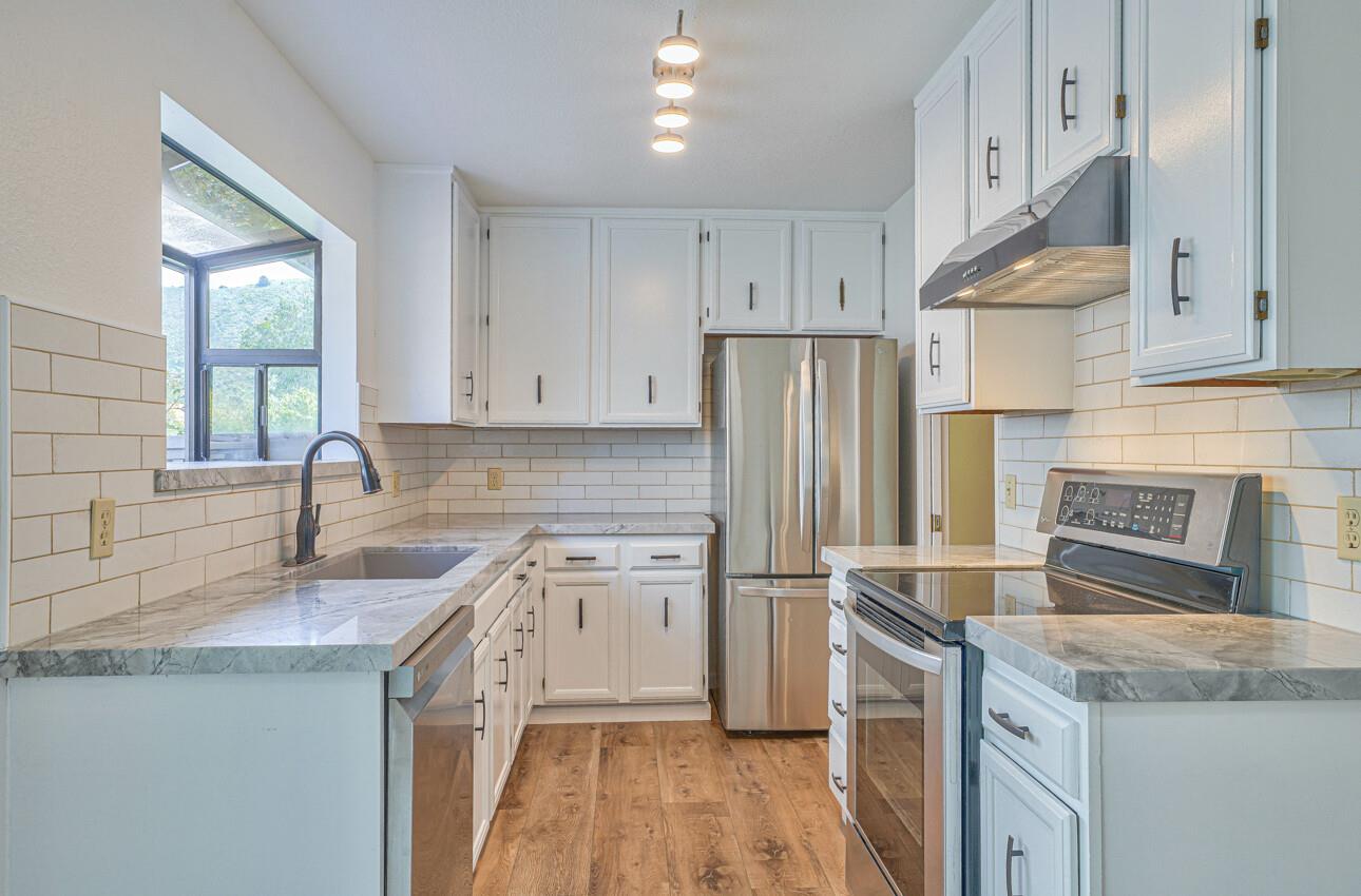 a kitchen with stainless steel appliances granite countertop a sink stove and refrigerator