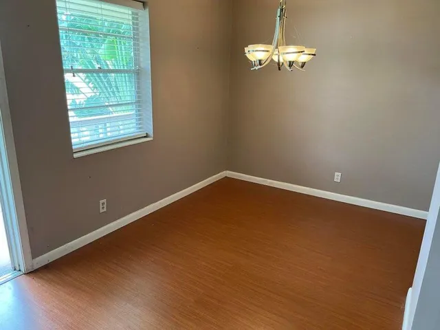 a view of a room with wooden floor and a window