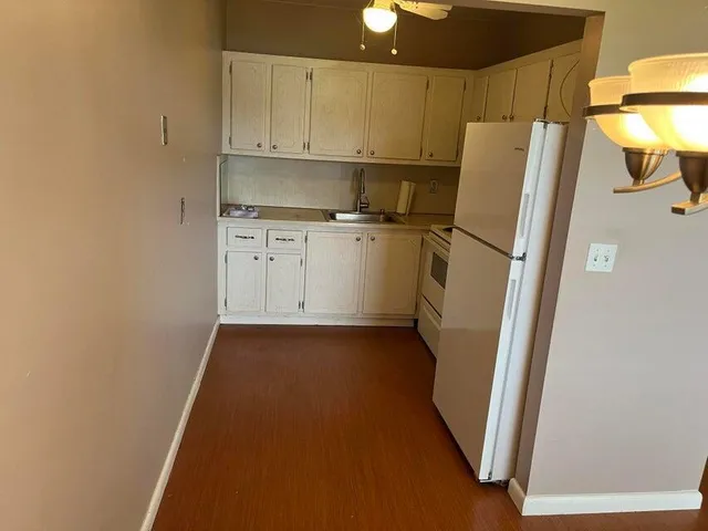 a view of a kitchen with refrigerator and a sink