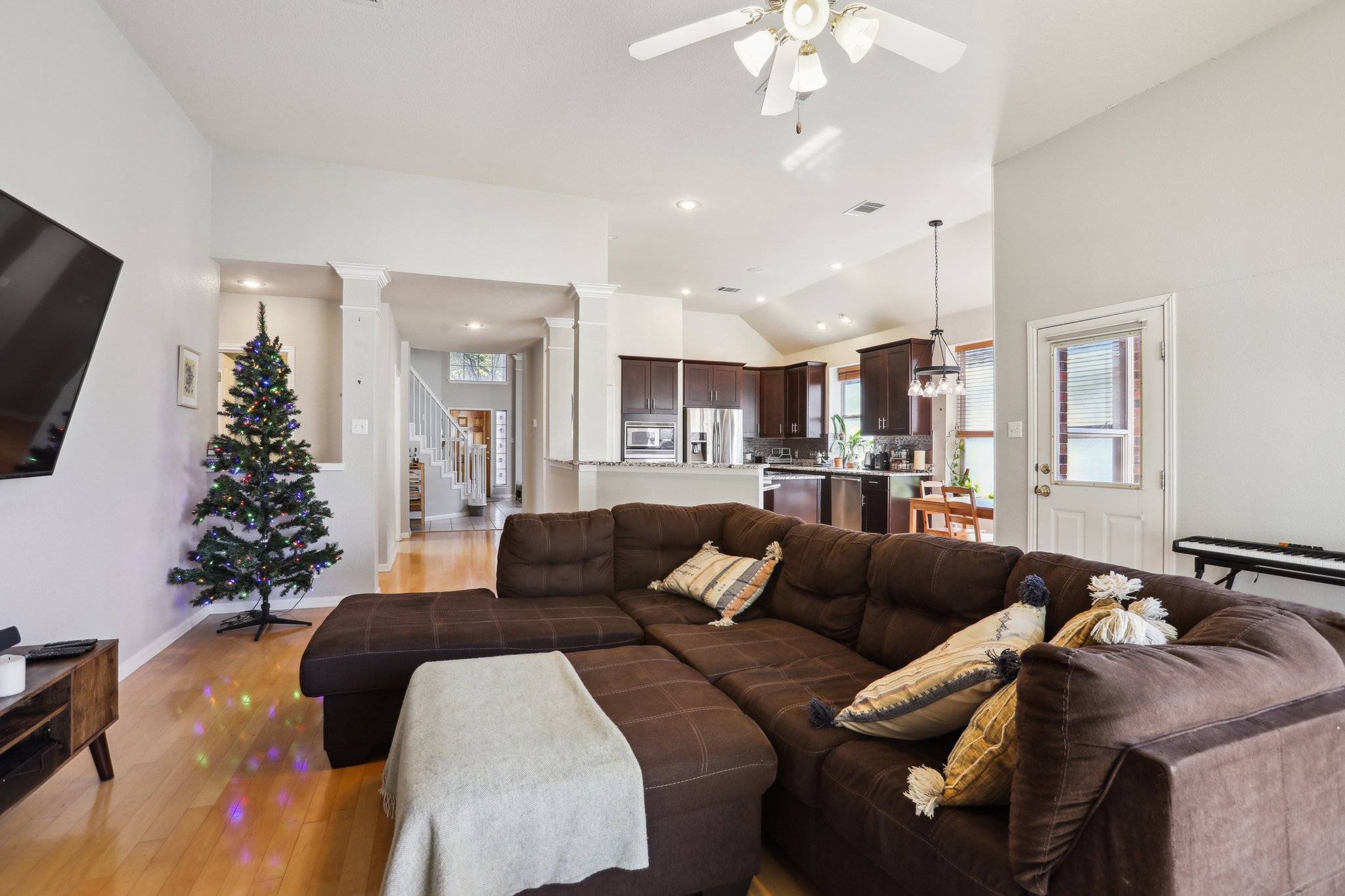 13541 Anarosa Loop Austin, TX 78727 - Photo 6 of 27 Spacious living area featuring light wood-finish flooring, high vaulted ceilings, and a ceiling fan