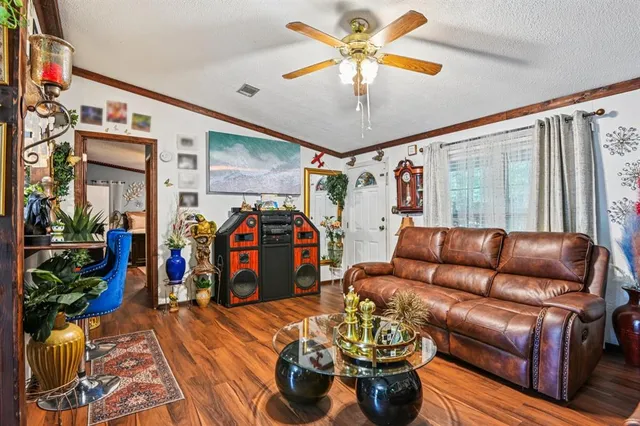a living room with furniture a chandelier and a flat screen tv