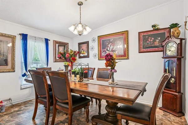 a view of a dining room with furniture a chandelier and wooden floor