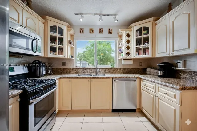 a kitchen with stainless steel appliances granite countertop a refrigerator and a stove