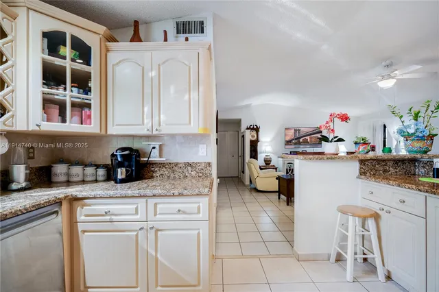 a kitchen with granite countertop a refrigerator and a sink