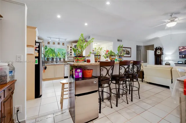 a kitchen with stainless steel appliances kitchen island granite countertop a table and chairs