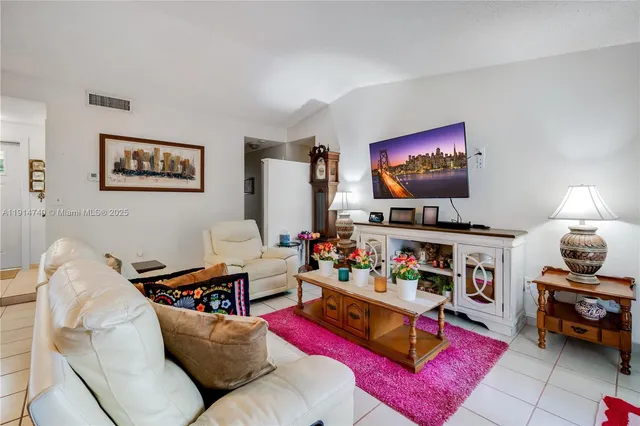 a living room with furniture a rug and a flat screen tv