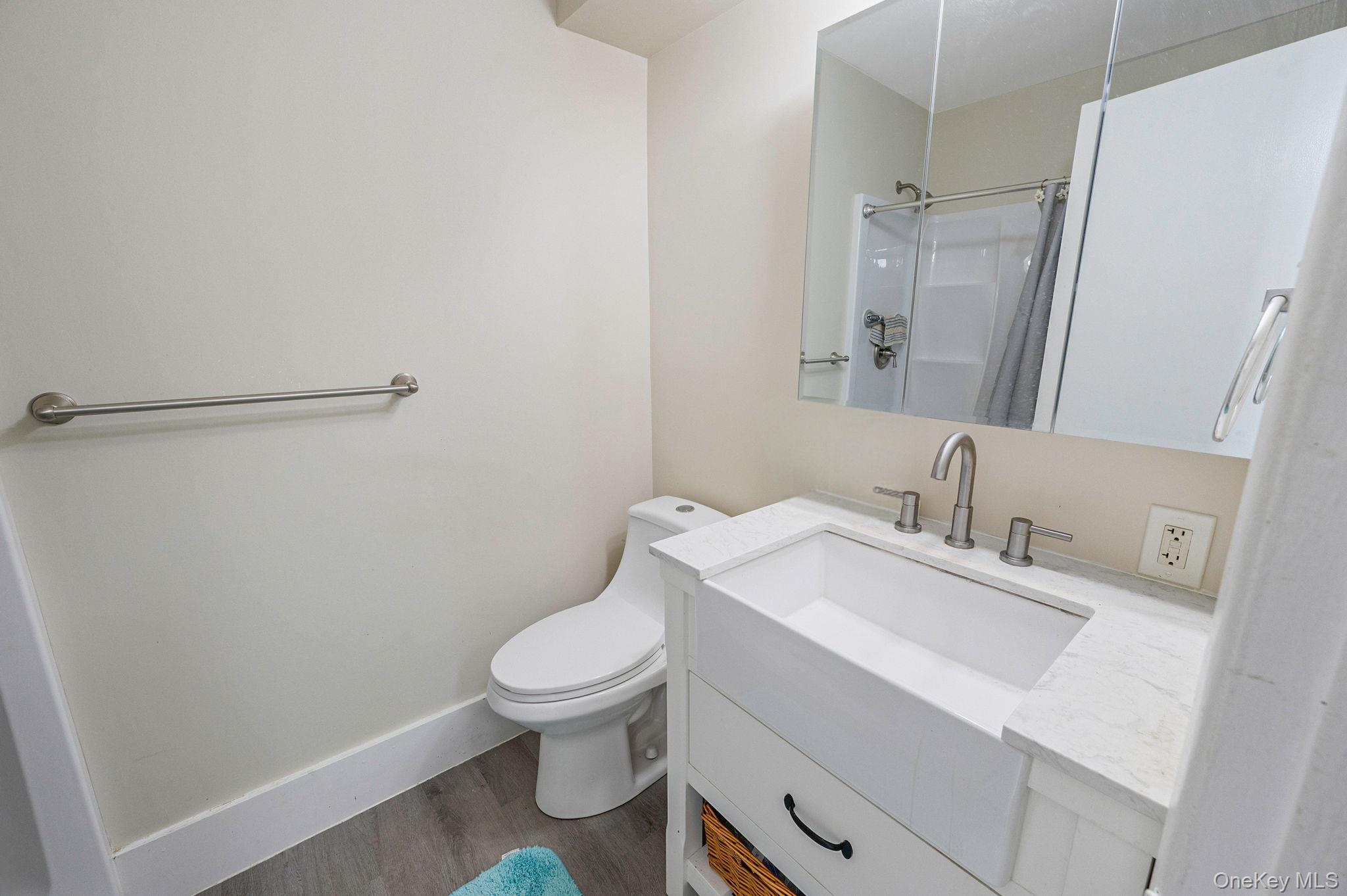 63 Rocky Point Yaphank Road, Unit 80 Rocky Point, NY 11778 - Photo 12 of 25 Bathroom with vanity, a shower with shower curtain, and wood finished floors