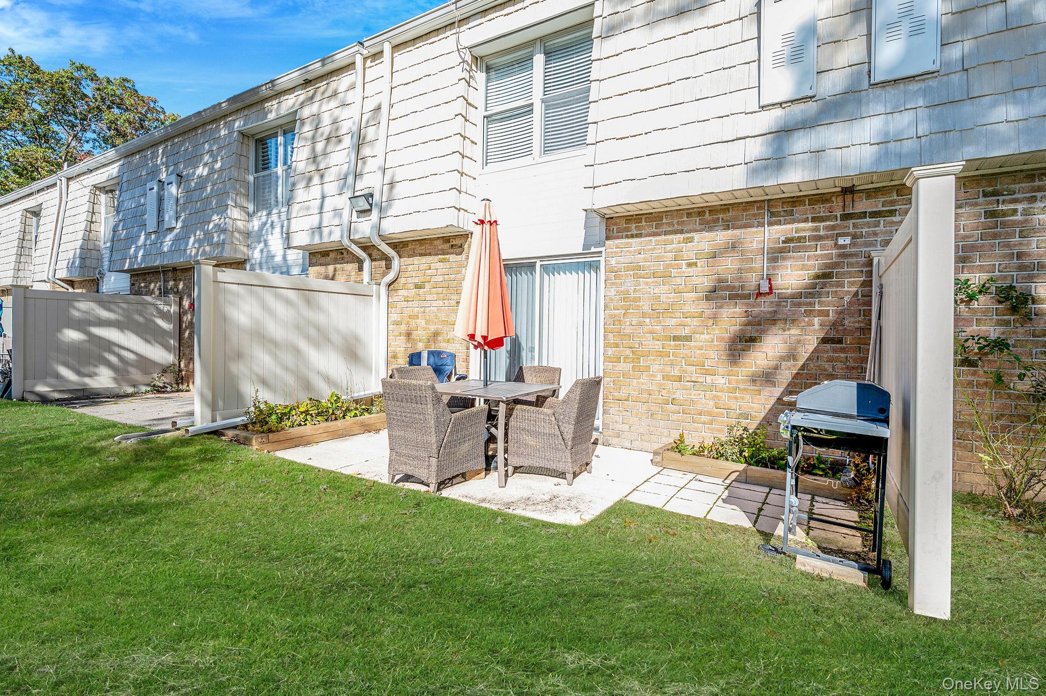63 Rocky Point Yaphank Road, Unit 80 Rocky Point, NY 11778 - Photo 19 of 25 Back of house with a patio and brick siding